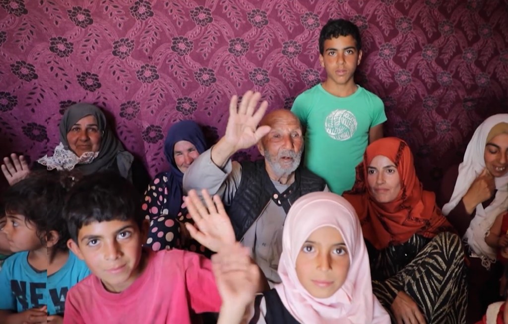 أبو جاسم (الوسط) وأسرته من بين اللاجئين السوريين العائدين إلى ديارهم.